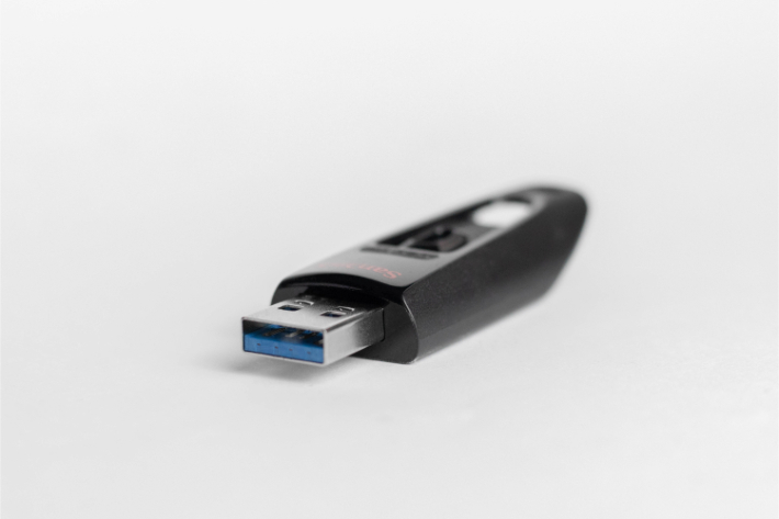 Ett USB-minne som ligger på ett skrivbord: en påminnelse om att undvika att använda okända flyttbara lagringsenheter för att inte drabbas av utpressningsvirus