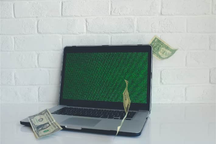 Hackad bärbar dator med amerikanska dollarsedlar som singlar ned
